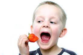 child eating a strawberry